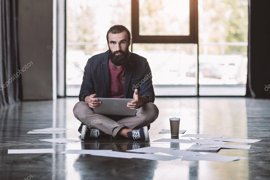 businessman with laptop sitting on floor