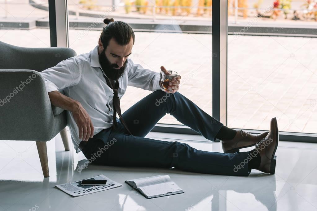 drunk businessman sitting on floor