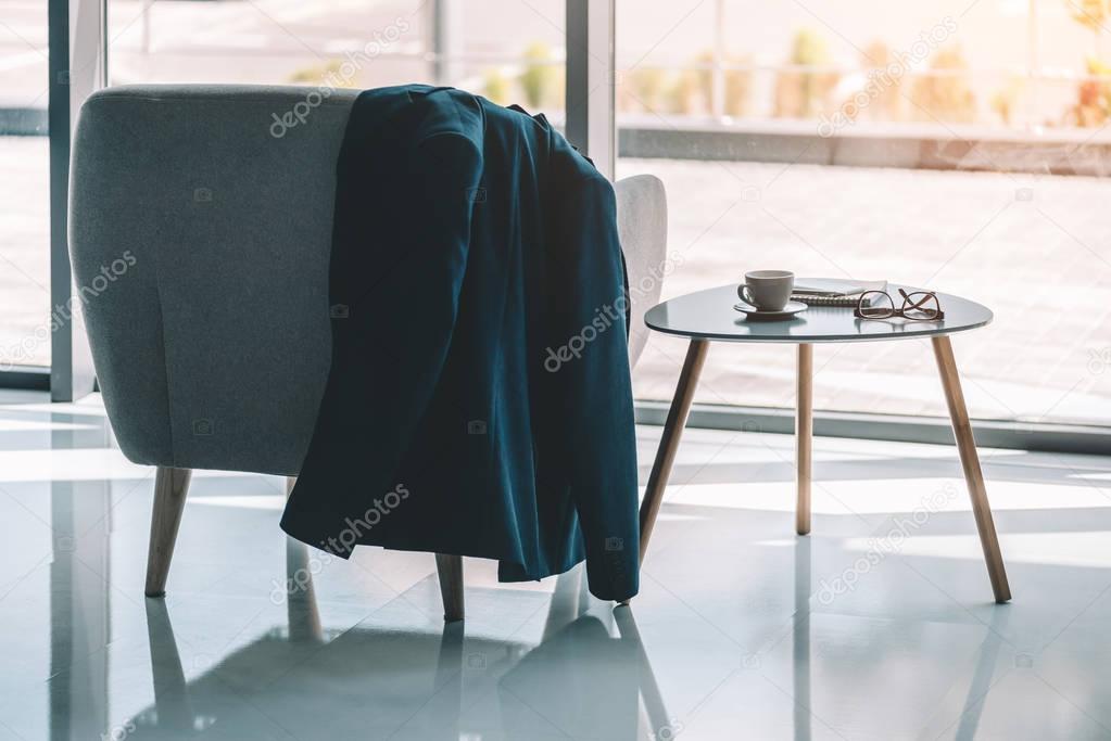 businessmans jacket hanging on armchair