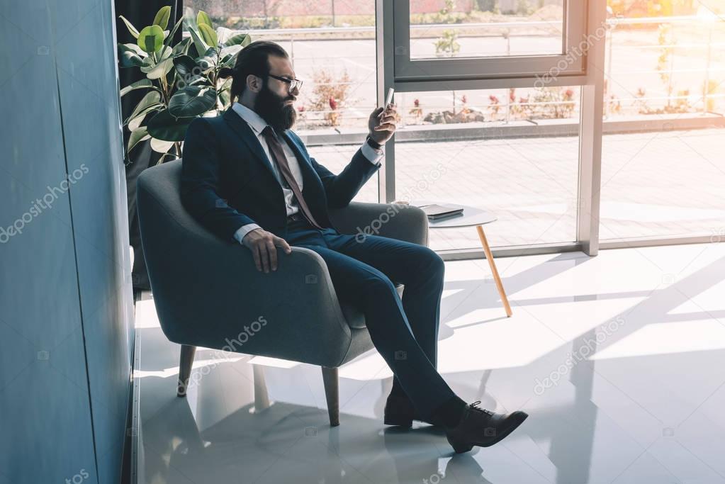 serious businessman using smartphone