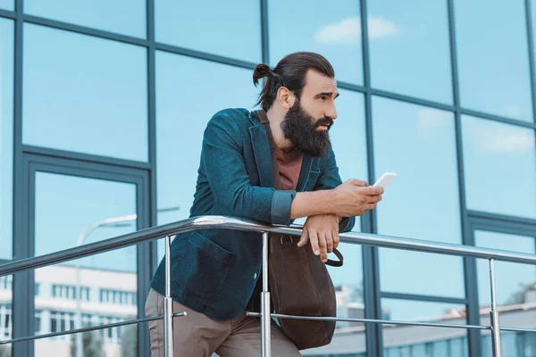 Бородатый бизнесмен с помощью смартфона — стоковое фото