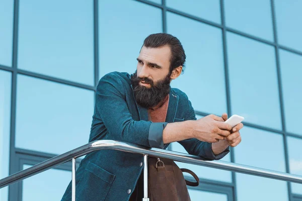 Бородатый бизнесмен с помощью смартфона — стоковое фото