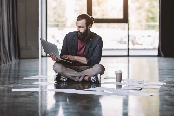Бизнесмен с ноутбуком на полу — стоковое фото
