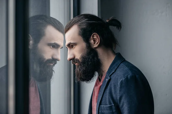 Man looking at reflection in glass — Stock Photo