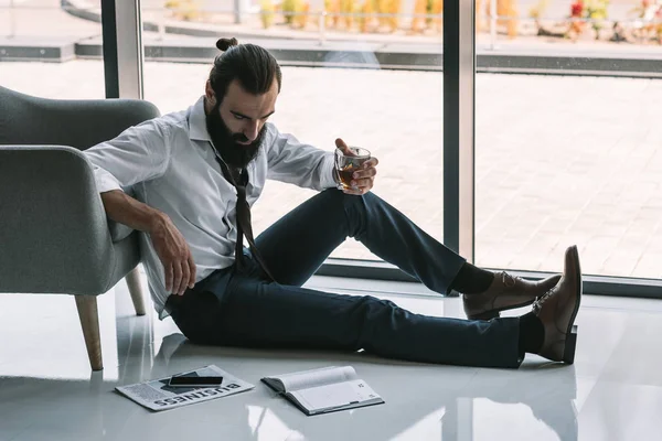 Drunk businessman sitting on floor — Stock Photo