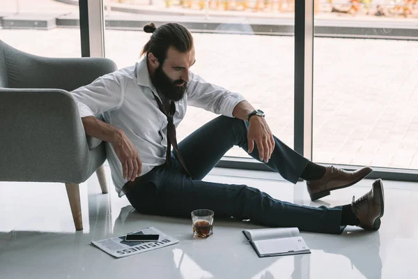 Drunk businessman sitting on floor — Stock Photo