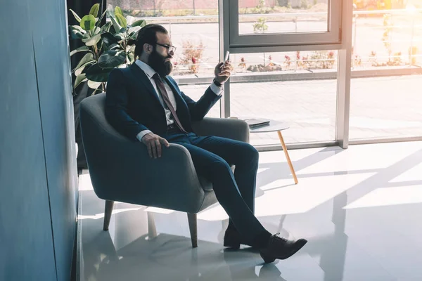 Hombre de negocios serio usando teléfono inteligente - foto de stock