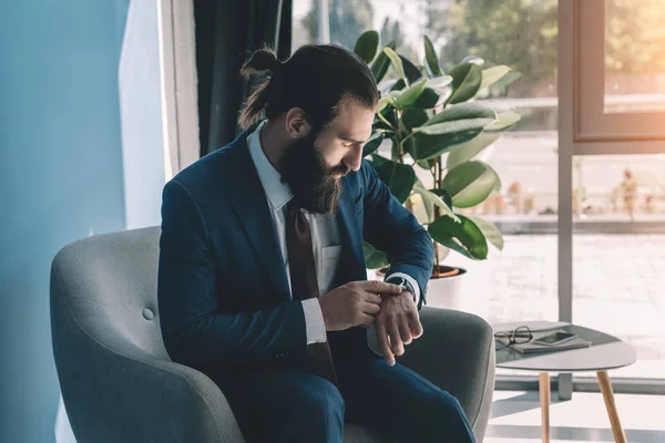 Hombre de negocios guapo mirando el reloj - foto de stock