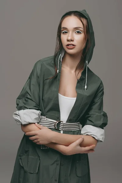 Schönes junges Mädchen posiert in Regenmantel, isoliert auf grau — Stockfoto