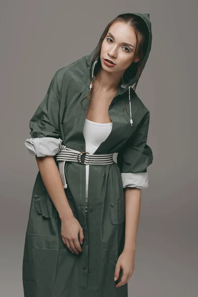 Stylish girl posing in green autumn raincoat, isolated on grey — Stock Photo