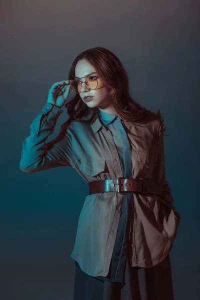 Niña posando en traje de otoño y gafas de sol amarillas, aisladas en gris - foto de stock