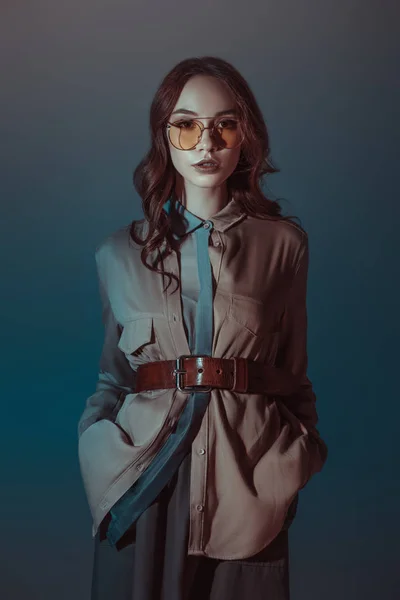 Fille à la mode posant en tenue d'automne et lunettes de soleil, isolé sur gris — Photo de stock