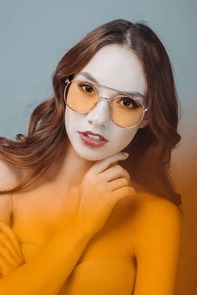Menina elegante posando em óculos de sol amarelos, isolado em cinza — Fotografia de Stock