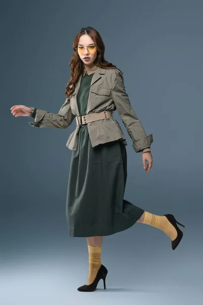 Stylish girl posing in autumn outfit for fashion shoot, isolated on grey — Stock Photo