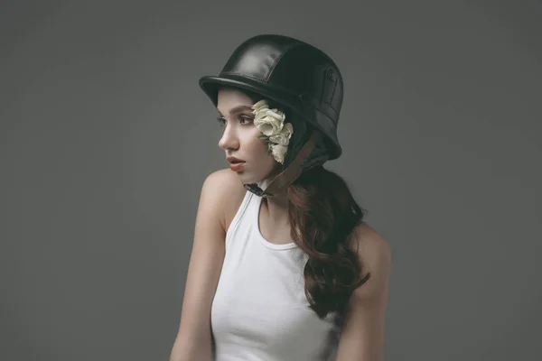 Beautiful young girl in military helmet with white roses, isolated on grey — Stock Photo