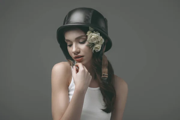 Bella tenera ragazza in casco militare con fiori, isolata su grigio — Foto stock