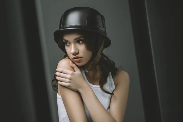 Беспокойная молодая девушка в военном шлеме для модной съемки — стоковое фото