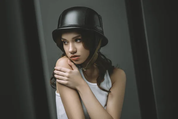 Worried young girl in military helmet for fashion shoot — Stock Photo