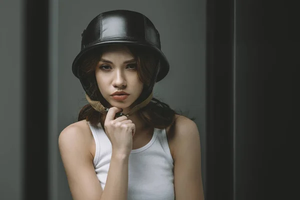 Вдумчивая молодая девушка в военном шлеме для модной съемки — стоковое фото