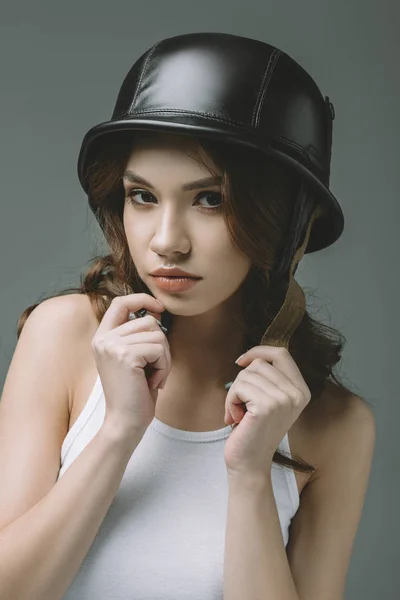 Beautiful young girl in military helmet, isolated on grey — Stock Photo