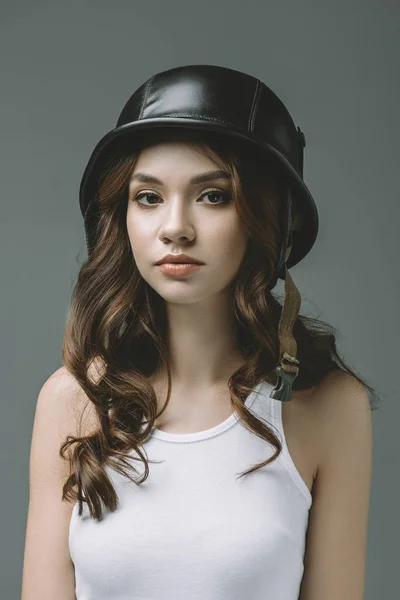 Привлекательная молодая девушка в военном шлеме, изолированная на сером — стоковое фото