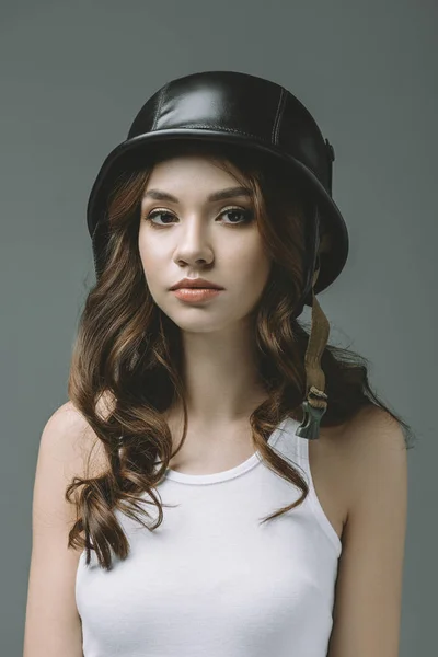 Attractive young girl in military helmet, isolated on grey — Stock Photo