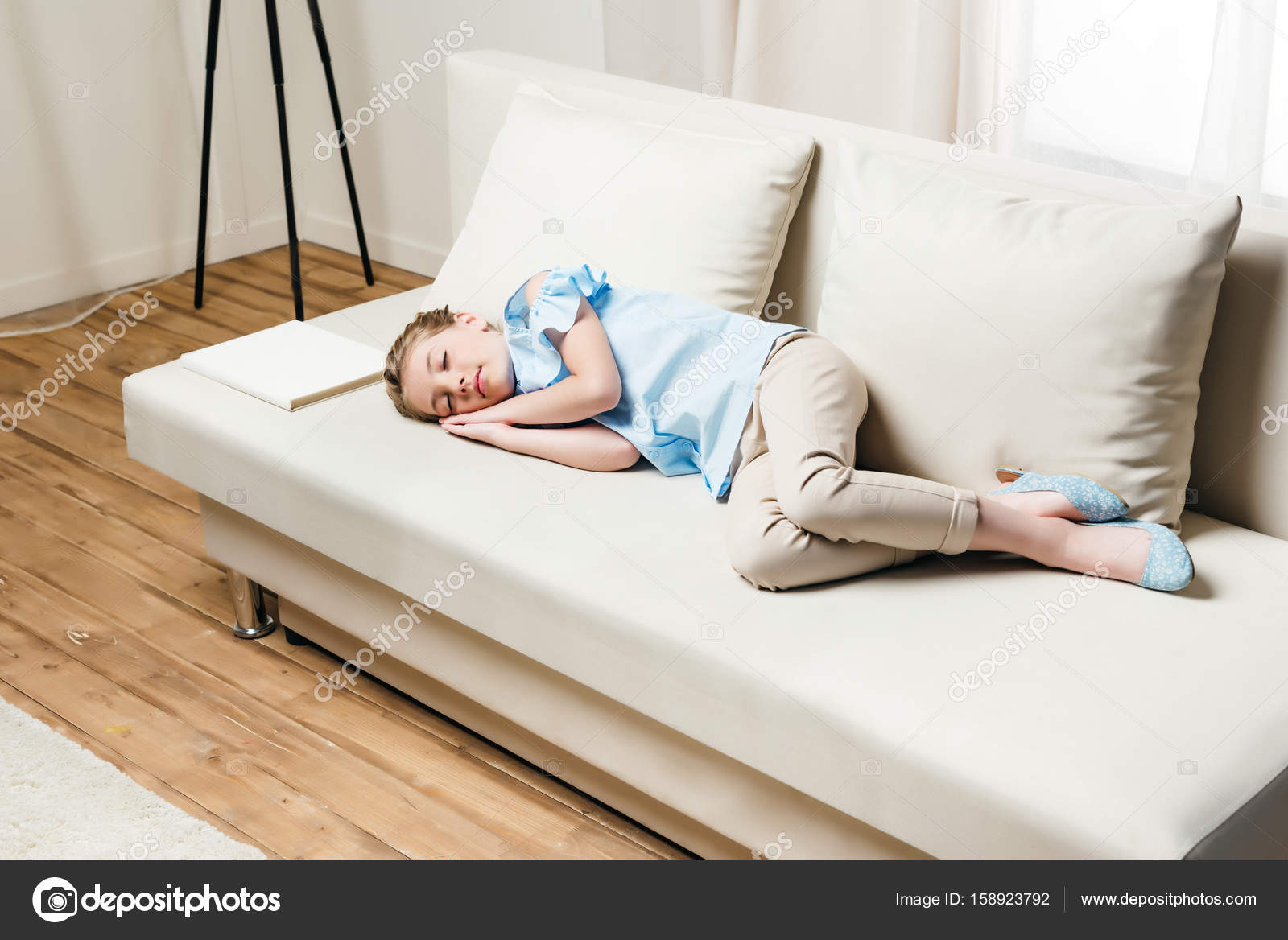 Girl sleeping on sofa with book — Stock Photo © EugeneGensyurovksy