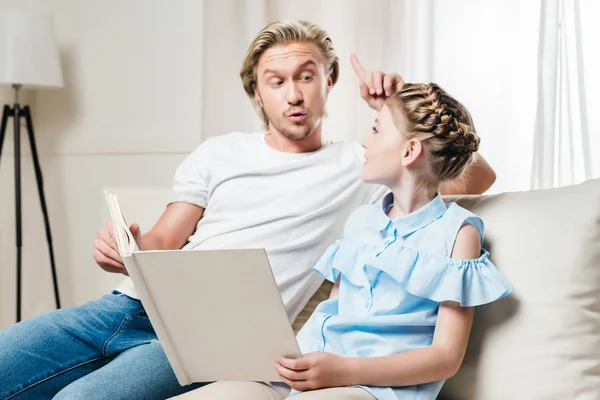 Far og datter leser bok – stockfoto