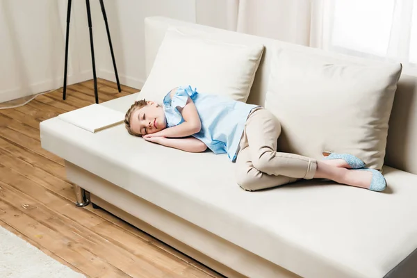 Κορίτσι κοιμάται στον καναπέ με βιβλίο — Φωτογραφία Αρχείου