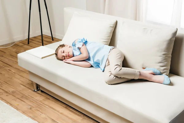 Girl sleeping on sofa with book — Stock Photo, Image