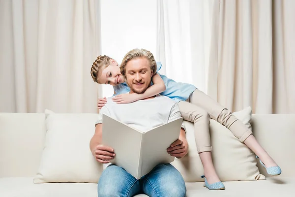 Far og datter læser bog - Stock-foto