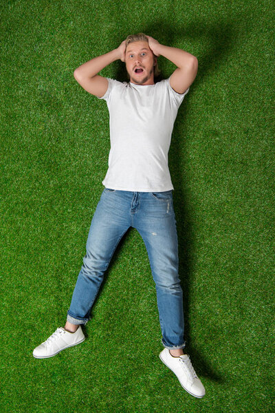 astonished man lying on meadow