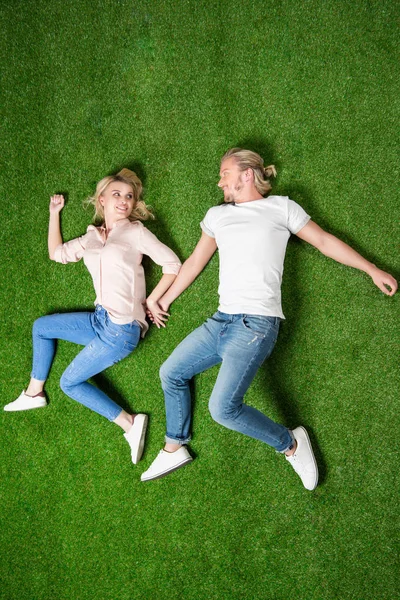 Young couple lying on grass — Stock Photo, Image