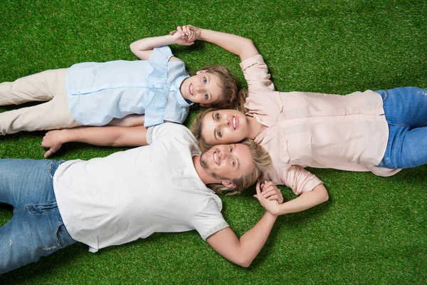 Family lying on grass — Stock Photo, Image