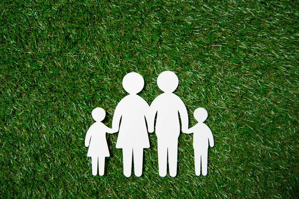 Paper cut of family on grass — Stock Photo, Image