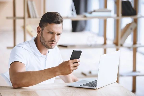 Homme d'affaires avec smartphone sur le lieu de travail — Photo