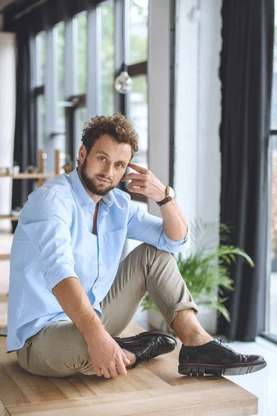 Businessman sitting on table — Free Stock Photo