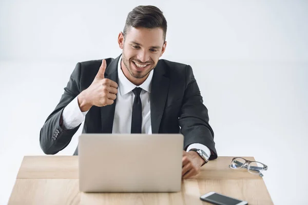Businessman showing thumb up at workplace — Stock Photo, Image