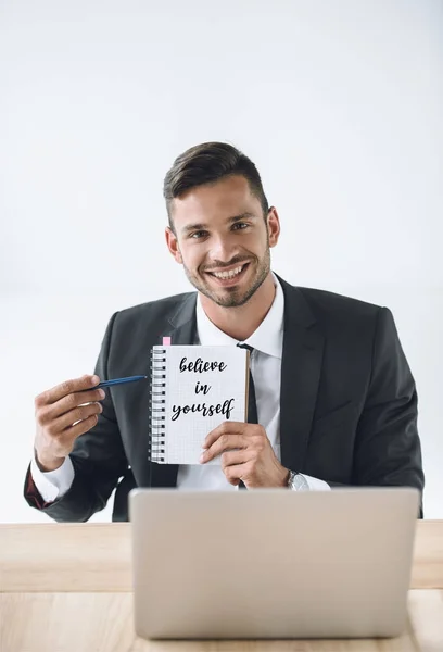 Uomo d'affari che indica notebook — Foto stock gratuita