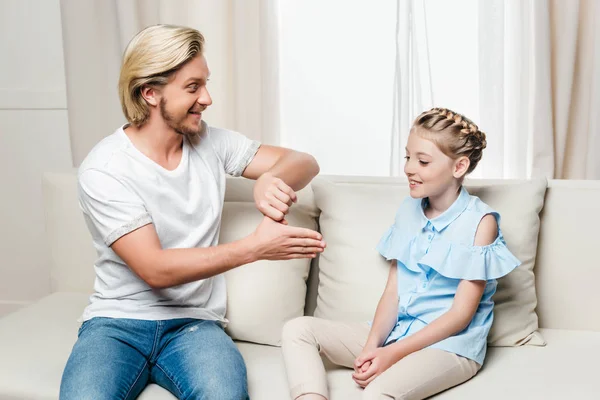 Padre mostrando truco a hija en casa - foto de stock