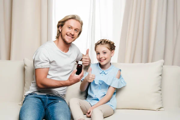 Pai e filha segurando medicina — Fotografia de Stock