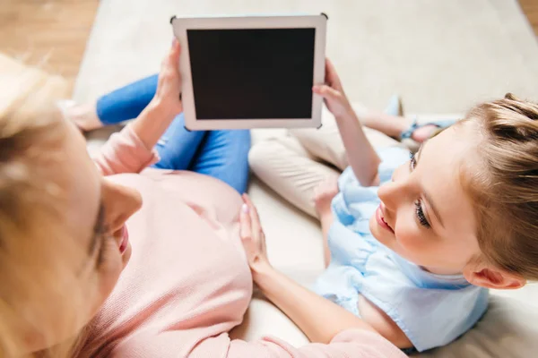 Madre con hija usando tableta digital - foto de stock