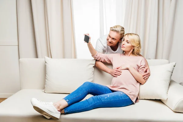 Pareja embarazada usando smartphone — Stock Photo