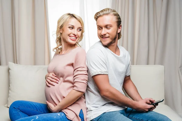Pareja embarazada usando smartphone — Stock Photo