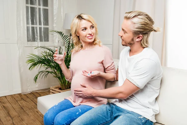 Husband with pregnant wife holding medicine — Stock Photo