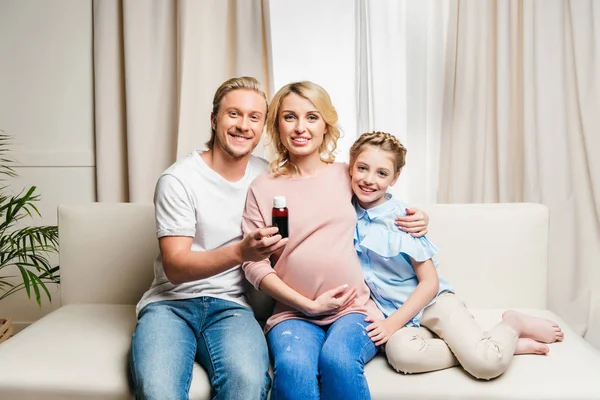 Man showing bottle with family near by — Stock Photo