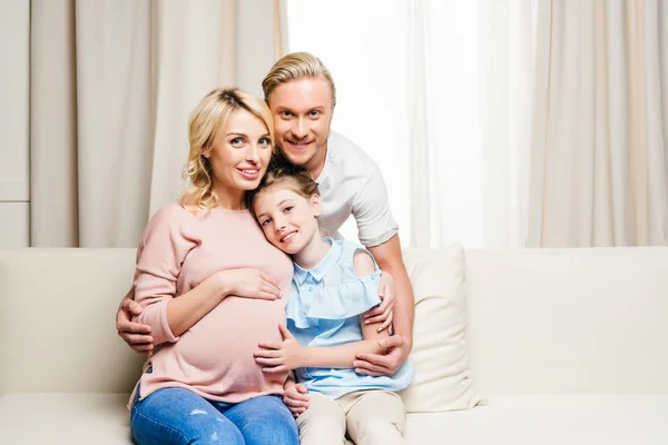 Familia feliz sentado en el sofá - foto de stock