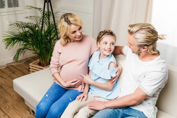 Happy family sitting on sofa — Stock Photo