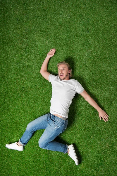 Man lying in funny position on meadow — Stock Photo