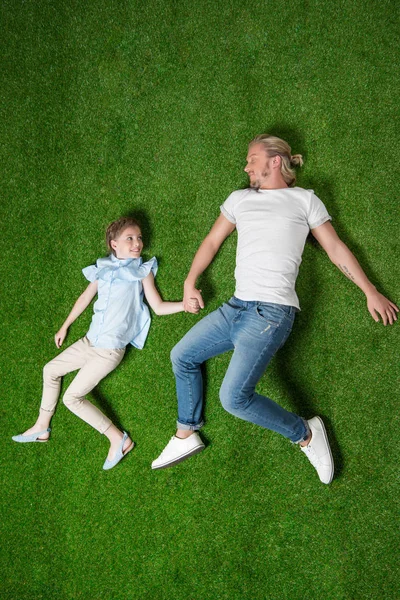 Père avec fille couché sur l'herbe — Photo de stock